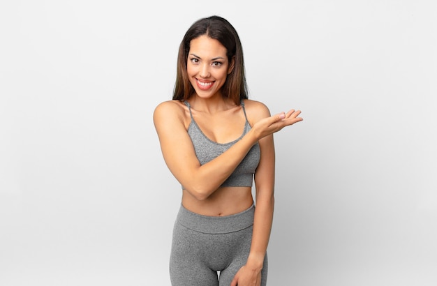 Young hispanic woman smiling cheerfully, feeling happy and showing a concept. fitness concept