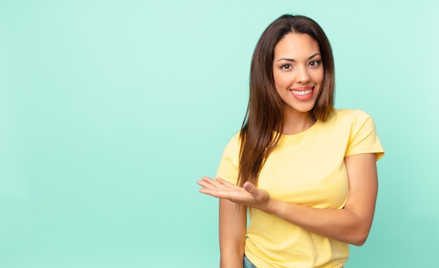 Young hispanic woman smiling cheerfully, feeling happy and showing a concept