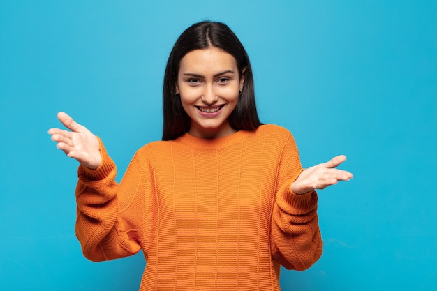 Young hispanic woman smiling cheerfully giving a warm, friendly, loving welcome hug, feeling happy and adorable