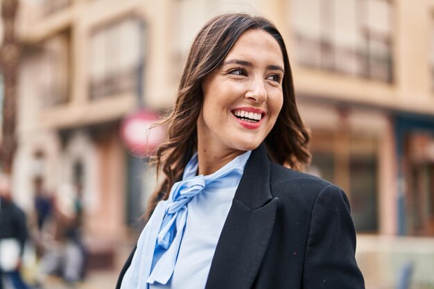 Young hispanic woman smiling confident standing at street