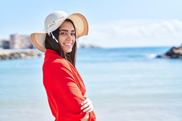 Young hispanic woman smiling confident wearing bikini and summer hat at seaside