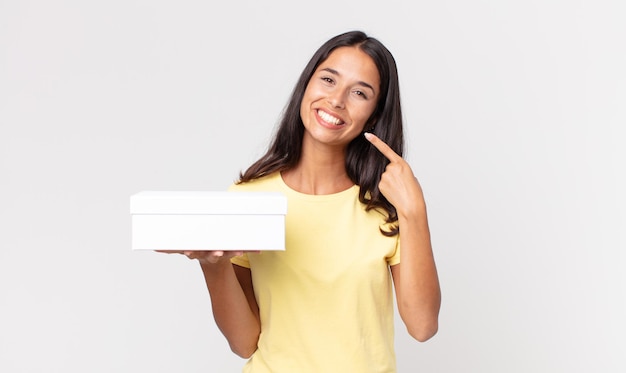 Young hispanic woman smiling confidently pointing to own broad smile