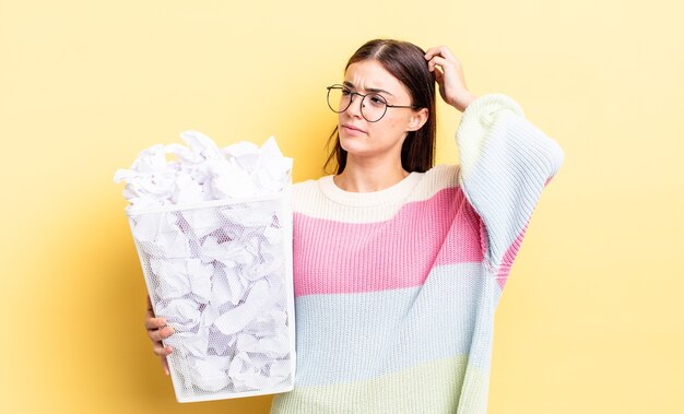 幸せに笑って、空想にふけったり、疑ったりする若いヒスパニック系女性。失敗ゴミの概念