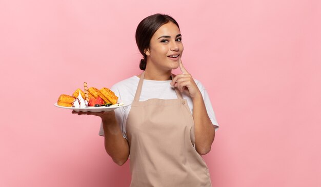 Young hispanic woman smiling happily and daydreaming or doubting, looking to the side