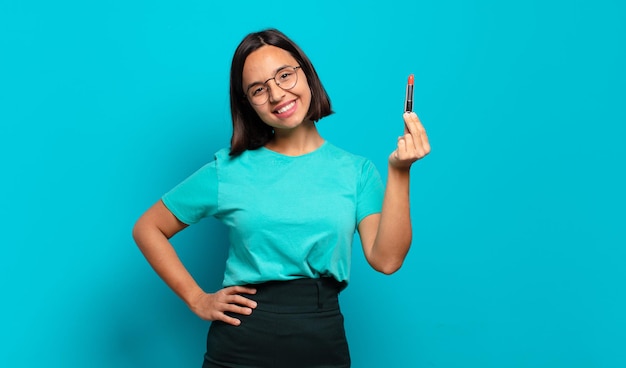 Young hispanic woman smiling happily with a hand on hip and confident, positive, proud and friendly attitude