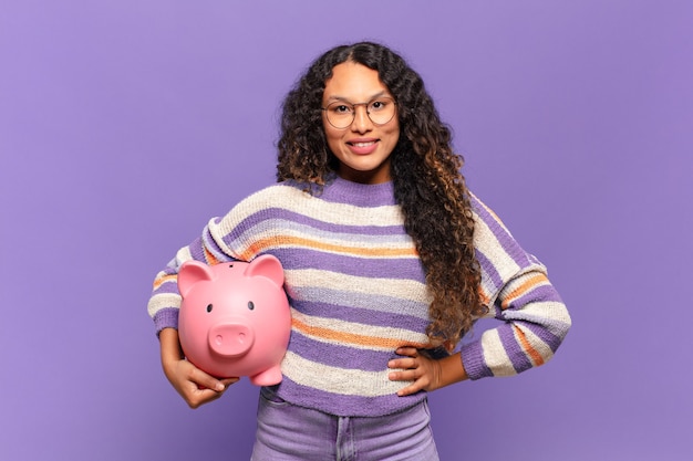 Young hispanic woman smiling happily with a hand on hip and confident