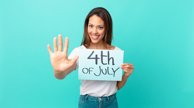 Young hispanic woman smiling and looking friendly, showing number five. independence day concept