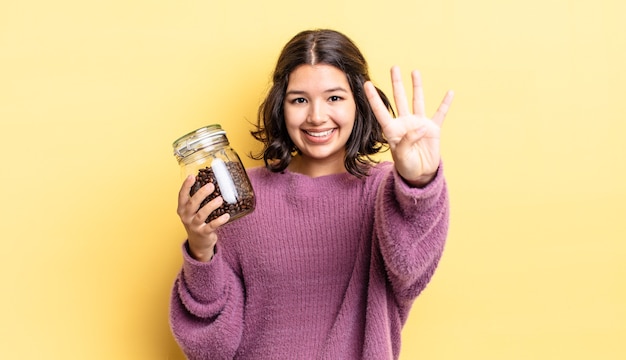 Young hispanic woman smiling and looking friendly, showing number four. coffee beans concept