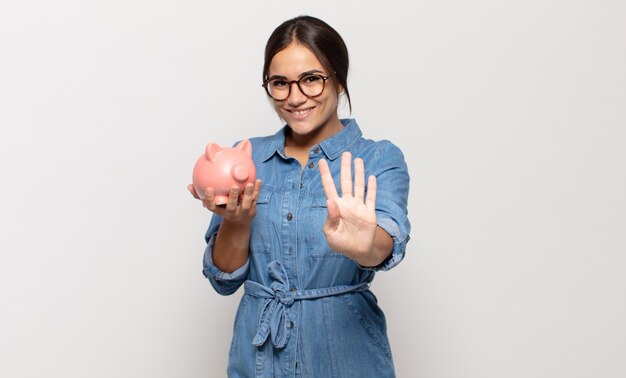 Young hispanic woman smiling and looking friendly, showing number four or fourth with hand forward, counting down