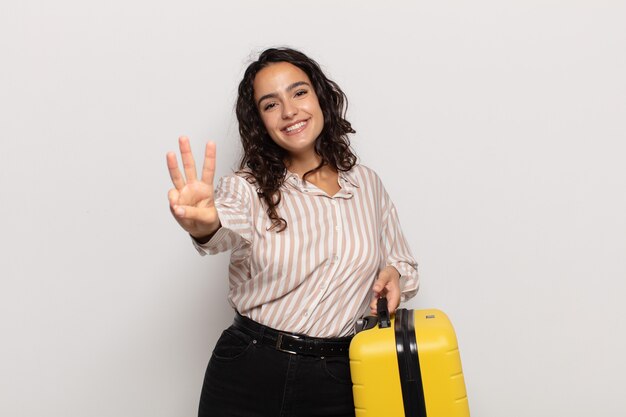 Young hispanic woman smiling and looking friendly, showing number three or third with hand forward, counting down