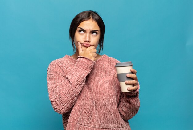 Young hispanic woman thinking, feeling doubtful and confused, with different options, wondering which decision to make