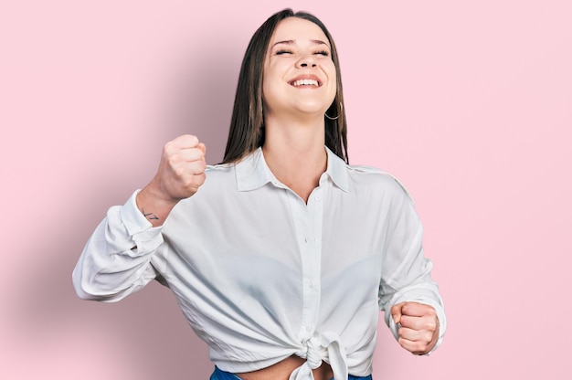 Young hispanic woman wearing casual clothes celebrating surprised and amazed for success with arms raised and eyes closed