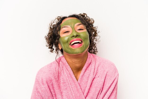 Young hispanic woman wearing a facial mask isolated on white background laughing and having fun