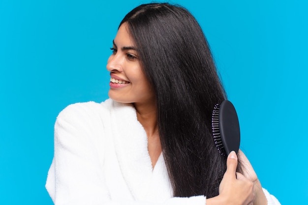 Young hispanic woman with a hair brush.