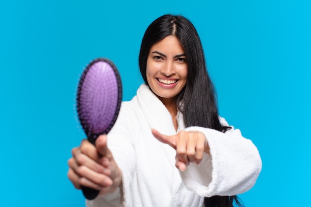 ヘアブラシを持つ若いヒスパニック系女性。