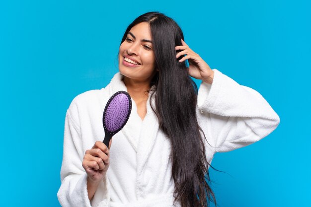 Young hispanic woman with a hair brush.
