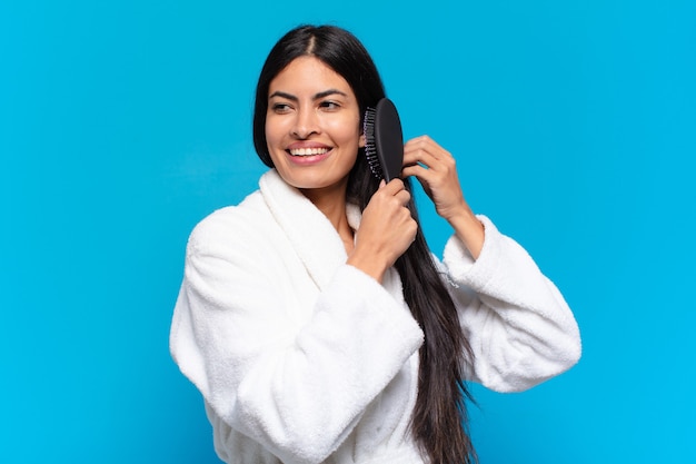 Young hispanic woman with a hair brush.