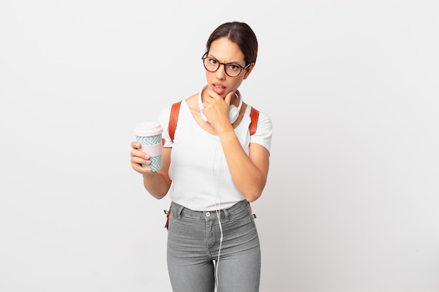 Young hispanic woman with mouth and eyes wide open and hand on chin. student concept