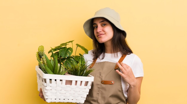 Young hispanic woman with plants gardering concept