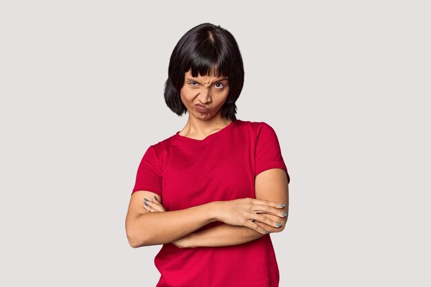 Photo young hispanic woman with short black hair in studio frowning face in displeasure keeps arms folded