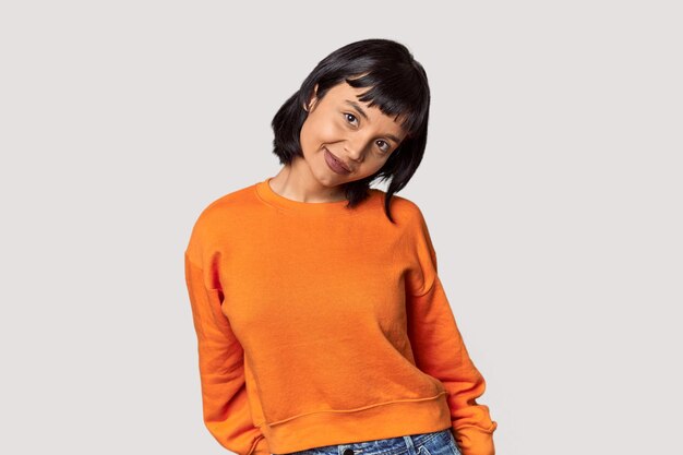 Young Hispanic woman with short black hair in studio happy smiling and cheerful