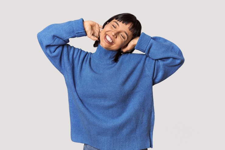 Photo スタジオで腕を伸ばしてリラックスした位置で短い黒髪の若いヒスパニック系女性