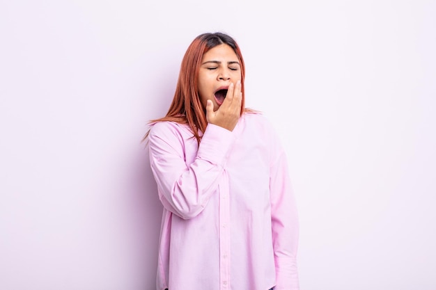 Young hispanic woman yawning lazily early in the morning, waking and looking sleepy, tired and bored