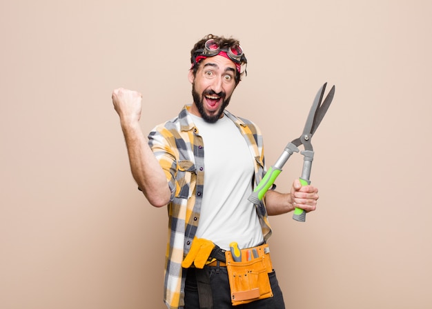 Young housekeeper with a scissors against flat wall