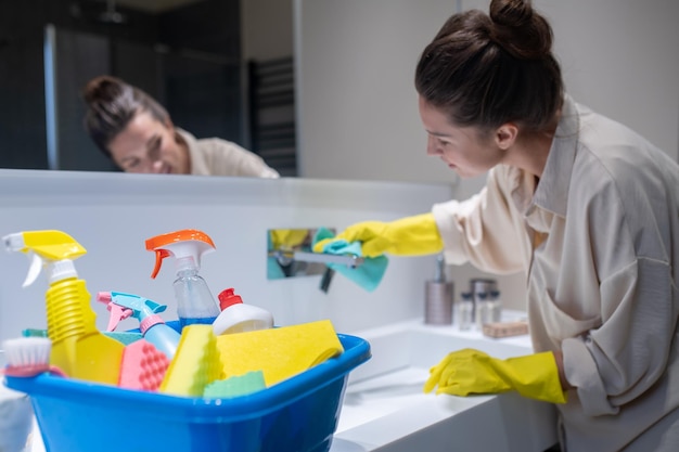 A young housewife cleaning in the bathroom