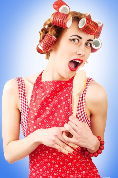 Photo young housewife singing with spoon