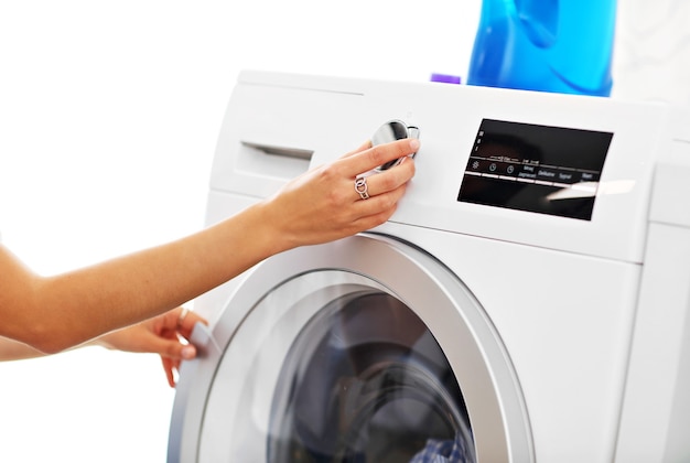 young housewife with laundry next to washing machine