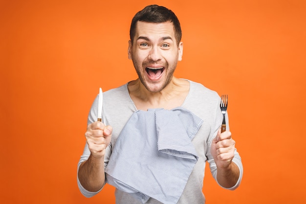 Young hungry crazy man holding a fork and a knife