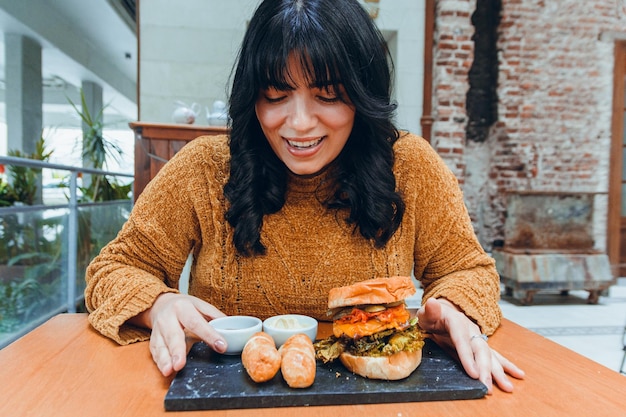 昼食に満足している若い空腹のラテン女性