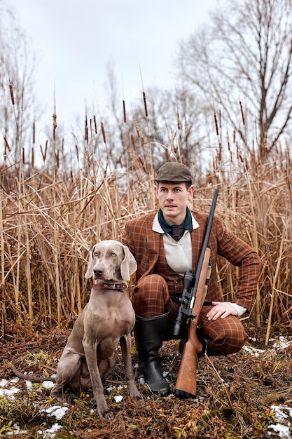 Young hunter male hunt on ducks in autumn, in nature. friendly Dog help him to hunt