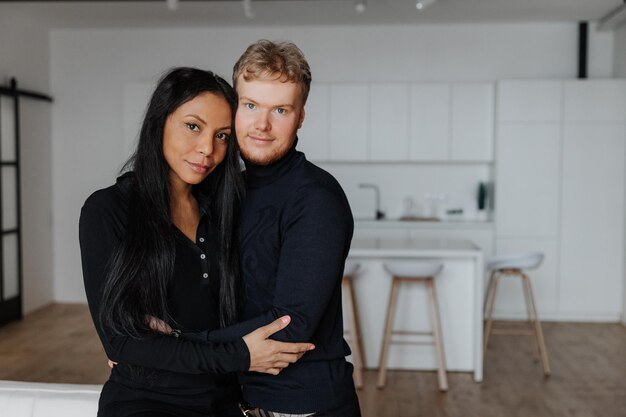 Young husband gently hugs his wife in the living room