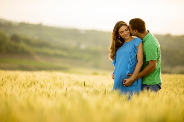 若い夫と彼の妊娠した妻の夏の畑