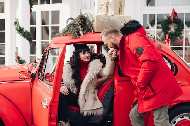 Young husband kisses his wife's hand as she gets out of car