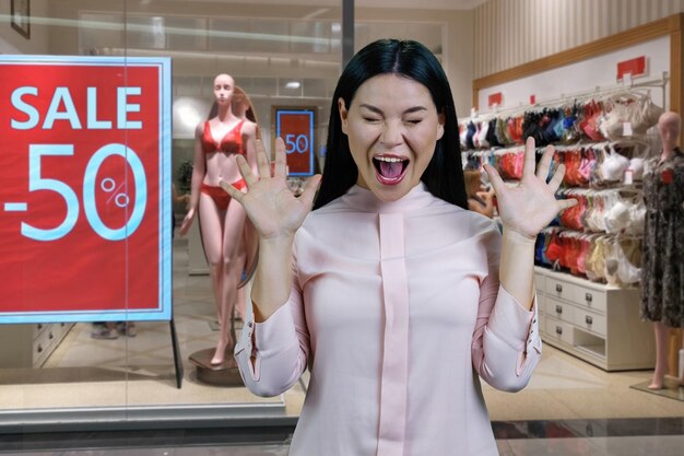 Young hysterical asian woman screaming out loud lingerie boutique with half discount in the backgrou