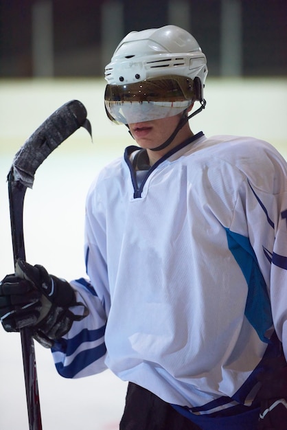 Фото Портрет молодого хоккеиста на тренировке на черном фоне