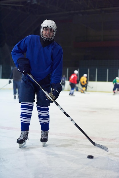Foto ritratto di giovane giocatore di hockey su ghiaccio sulla formazione in sfondo nero