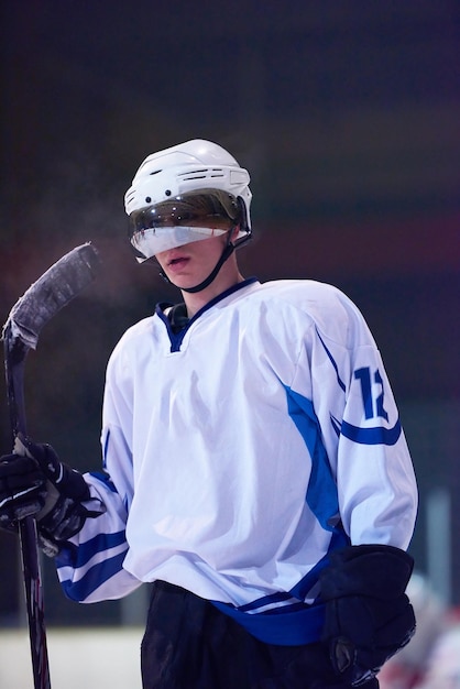 Foto ritratto di giovane giocatore di hockey su ghiaccio sulla formazione in sfondo nero