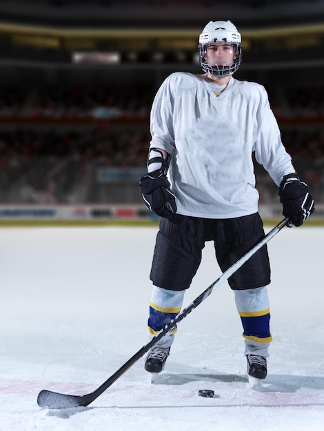 Портрет молодого хоккеиста на тренировке на черном фоне