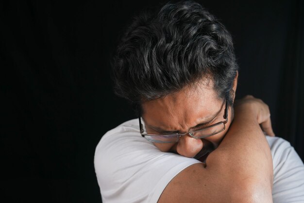 Young ill man covering her nose and mouth with arm