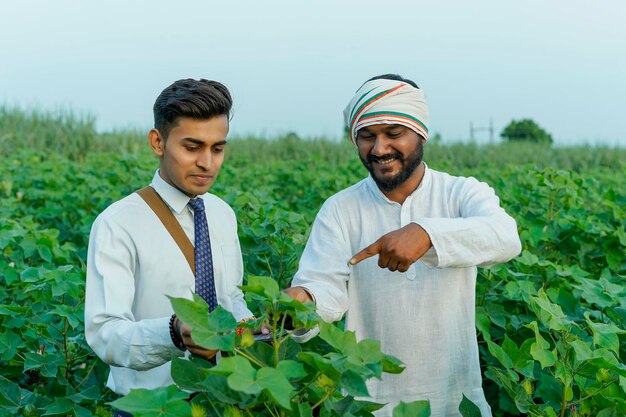 젊은 인도 농학자 나 은행가 가 농장 에서 농부 에게 어떤 정보 를 보여 주는 것
