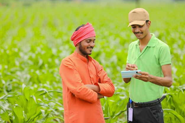 젊은 인도 농학자는 농업 분야에서 스마트폰으로 농부에게 일부 정보를 보여줍니다.