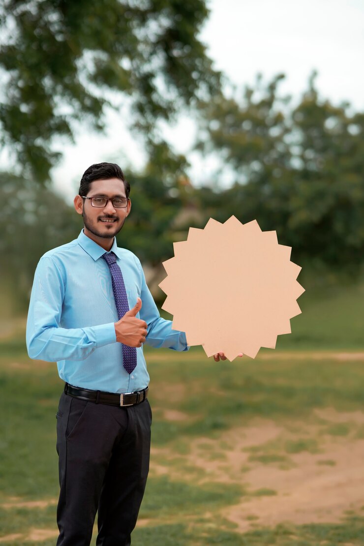 फोटो young indian banker or officer showing blank board on nature background.