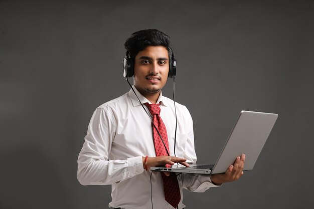 Young indian banker or officer using laptop