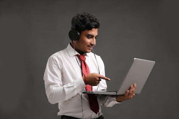 Молодой индийский банкир или офицер, использующий ноутбук