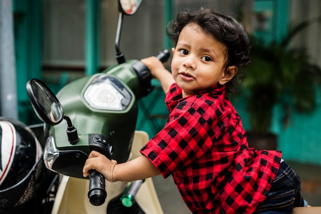 オートバイに乗っている若いインドの男の子