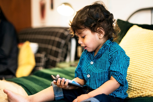 Photo young indian boy using mobile phone